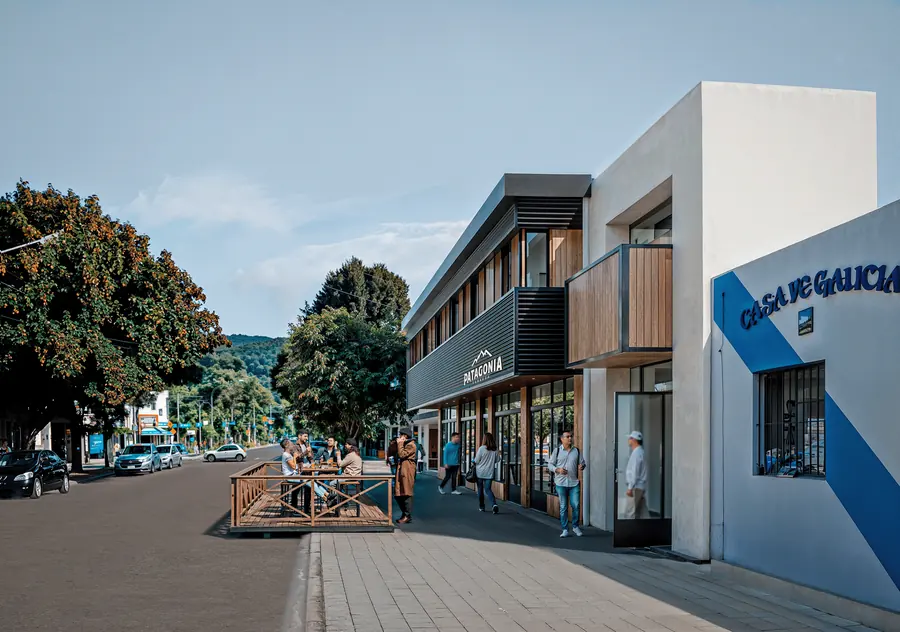 Render exterior de un bar con viviendas y vereda peatonal en la Patagonia